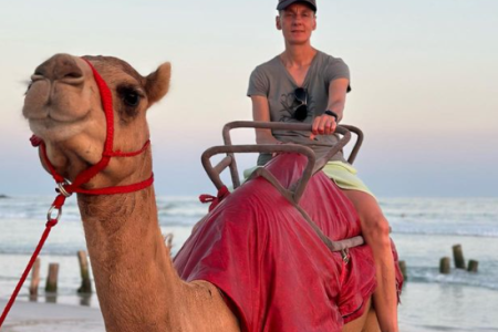 Cavalcata sui cammelli sulla spiaggia a Salalah
